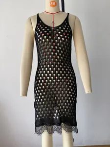 Detailed view of black hollow knit sleeveless dress featuring a delicate lace hem border