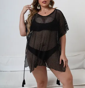 Detail of plus size black mesh beach cover-up with asymmetrical tassel hem design.