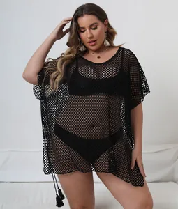 Close-up of black plus size mesh beach cover-up with asymmetrical hem and tassel details.