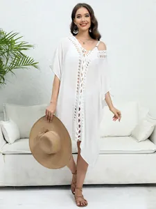 White solid-colored beach cover-up with hand-crocheted patchwork and V-neckline detail.