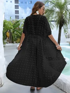 Elegante vestido de playa de gasa negra con lunares para mujer en un ambiente de resort
