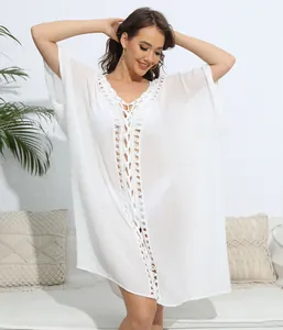 Loose fit white beach cover-up featuring intricate crochet V-neck and lace-up front detail