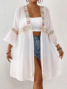 Detailansicht des weißen Boho-Überwurfs mit Paillettenstickerei und Spitzenbesatz