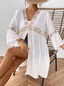 Detailansicht der bunten Paillettenstickerei und Spitzenapplikationen auf einem Strand-Cover-Up