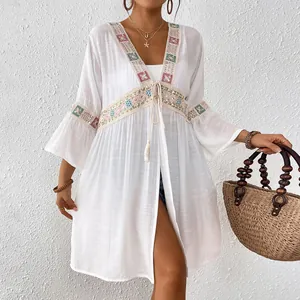 Detailansicht eines weißen Strand-Cardigans mit schöner Paillettenstickerei und Spitze