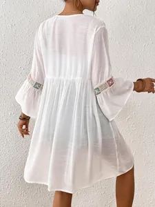 Rückenansicht des weißen Strand-Cover-ups mit fein bestickten Glockenärmeln aus Spitze
