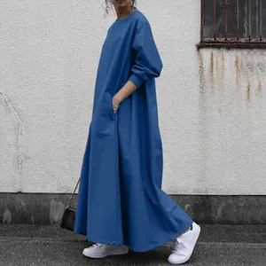 Side detail view of a loose blue long-sleeved maxi dress with functional side pockets