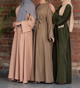 Detailed view of modest long-sleeved abaya dresses with belts in earthy solid colors