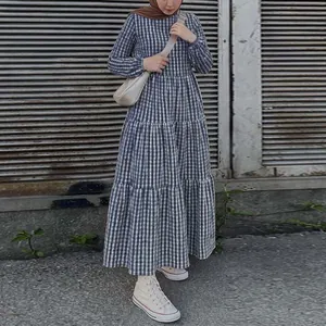Detailed shot of a blue gingham tiered maxi dress with long puff sleeves and tiered skirt.