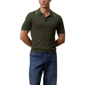 Macro view of the dark green knitted fabric and white tipped collar on this men's polo shirt.