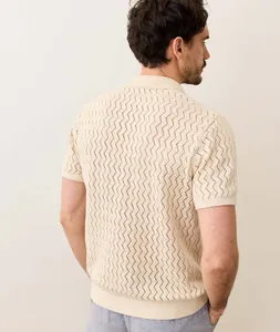 Detail view of men's beige hollow knit polo shirt showing textured crochet pattern