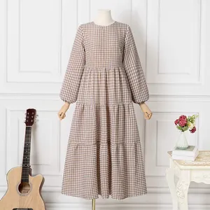 Detail of a brown gingham plaid maxi dress with tiered skirt and puff sleeves