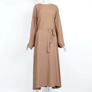 Front view of tan modest long-sleeved maxi dress with matching waist tie belt detail