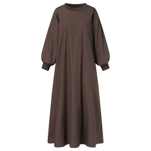 Detail of a brown loose-fit maxi dress showing round neck and ribbed long sleeve cuffs