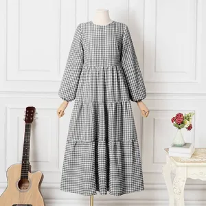 Elegant black and white gingham puff sleeve maxi dress shown in a stylish lifestyle setting.