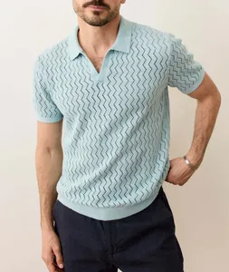 Detailed view of men's light blue knit polo shirt with wave-like hollow-out pointelle pattern