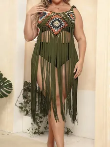 Detailed view of handmade crochet plus-size beach cover-up with long green fringes.