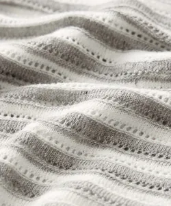 Close-up macro detail of grey and white striped hollow-out knit fabric texture for men