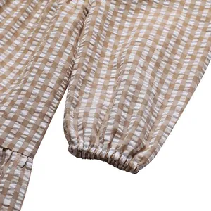 Detail of puff sleeve with elastic cuff on brown and white gingham dress fabric