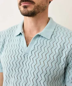 Close-up detail of light blue men's knit polo shirt with stylish zigzag hollow texture