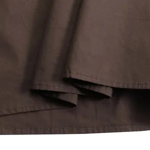 Detailed view of the texture and hem stitching of the brown solid color casual dress