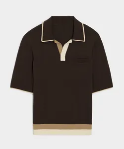 Detailed view of a men's brown knit polo shirt with cream color block hem and cuffs.