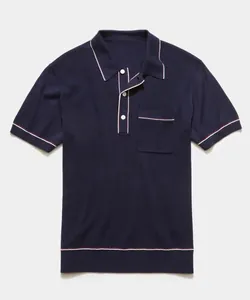 Close-up view of navy blue knitted Polo shirt with contrast white and red piping details.