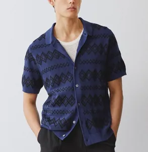 Detail view of a blue knitted men's polo cardigan with black geometric jacquard patterns