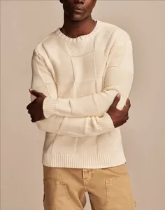 Dettaglio di un maglione da uomo in maglia a scacchi crema con eleganti motivi retrò