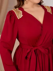 Elegant red plus size V-neck dress detail showing gold lace shoulder accents and waist tie