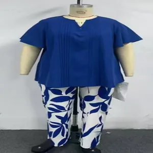 Ensemble grande taille deux pièces, haut bleu plissé à col en V et pantalon floral sur mannequin