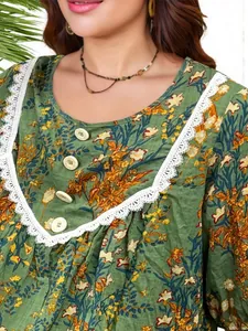 Detail view of a vintage green floral maxi dress with white lace trim and buttons.