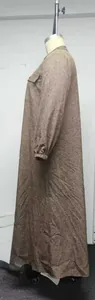 Side view detail of a loose-fit long brown textured maxi dress shown on a mannequin.