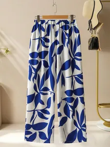 Détail du pantalon large à taille haute blanc avec motif de feuilles bleues d'été