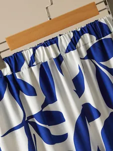 Gros plan sur la taille élastique et l'imprimé feuilles bleues d'un pantalon d'été