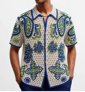 Close-up detail of men's white crochet knit polo shirt with blue and green paisley patterns