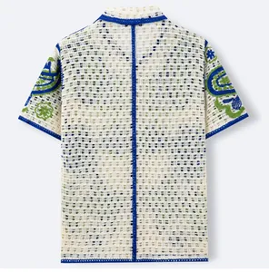 Back view of a white hollow-out crochet knit men's polo shirt with blue floral embroidery