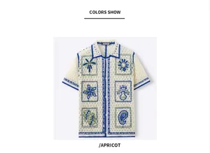 Detail view of men's apricot crochet knit polo shirt with blue trim and embroidered patterns.