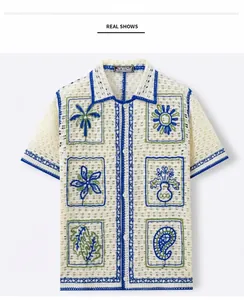 Close-up detail of men's resort style crochet knit shirt with blue piping and tropical embroidery