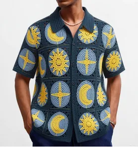 Détail rapproché du polo en crochet bleu marine avec motifs de soleil et de lune.
