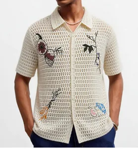 Detailed view of a men's crochet knit polo shirt with intricate nature embroidery and hollow design.