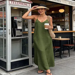 Elegante groene mouwloze maxi-jurk met V-hals in een café-omgeving in vakantiestijl