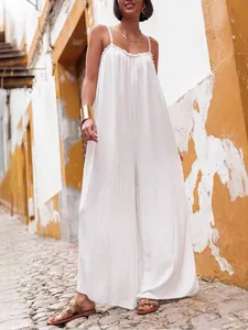 Combinaison d'été blanche en coton et lin avec bretelles spaghetti et jambes larges style vacances.