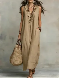 Close-up of bohemian linen maxi dress featuring elegant ruffle V-neck and tiered design.