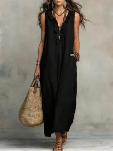 Detail view of a black bohemian cotton linen maxi dress with ruffle V-neck trim