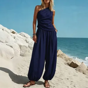 Elegant tweedelig marineblauw one-shoulder top en harembroek set op het strand