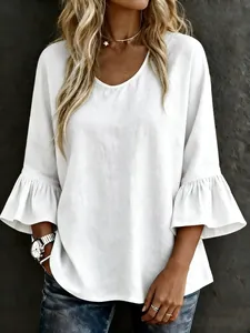 Detail view of the elegant flared ruffles on a white linen-blend bell-sleeve blouse.