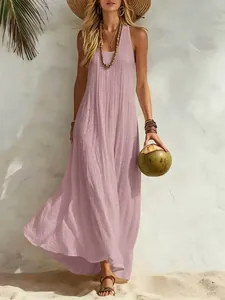 Elegant pink sleeveless maxi dress showing fabric texture in beach resort setting