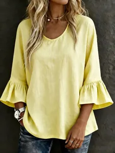 Close-up of light yellow linen blouse featuring stylish tiered ruffle bell sleeves.