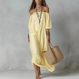 Elegante geel gestreepte maxi-jurk met blote schouders voor de zomervakantie aan zee